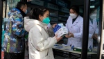 A resident carries away medicine bought at a pharmacy in Beijing, Friday, Dec. 9, 2022.  China began implementing a more relaxed version of its strict "zero COVID" policy on Thursday amid steps to restore normal life, but also trepidation over a possible broader outbreak once controls are eased. (AP Photo/Ng Han Guan)
