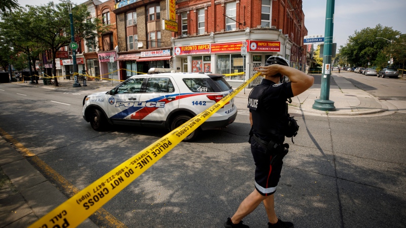 Police work the scene of a shooting in Toronto. THE CANADIAN PRESS/Cole Burston