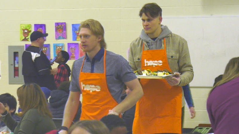 Jesse Puljujärvi and Edmonton-raised James Hamblin serve food at the Hope Mission's annual Tegler Family Christmas Banquet at Ivor Dent School on Dec. 8, 2022. 