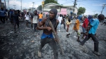 A protester carries a piece of wood simulating a weapon during a protest demanding the resignation of Prime Minister Ariel Henry in the Petion-Ville area of Port-au-Prince, Haiti, on Oct. 3, 2022. Citizen and business groups are rallying for a political consensus to get Haiti out of humanitarian and political crises, but remain split on the idea of a military intervention. THE CANADIAN PRESS/AP-Odelyn Joseph 