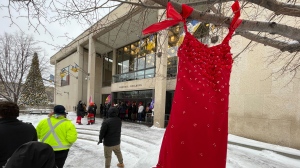 A red dress hangs on a tree in the courtyard of Winnipeg City Hall during a rally on Dec. 15, 2022 (CTV News Photo Jamie Dowsett)