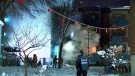 A Montreal police officer and firefighters are seen responding to a blaze in an apartment building near Atwater Ave and Notre-Dame St on Dec. 18, 2022 (Cosmo Santamaria, CTV News)