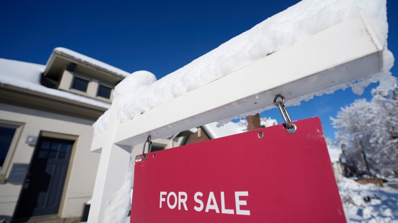 A layer of wet, heavy snow tops the arm of realty sign of a home for sale Thursday, Dec. 29, 2022, in Denver, Colorado. (AP Photo/David Zalubowski)
