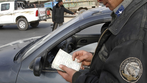 An Afghan police traffic officer checks documents of a vehicle at a check point in Kabul, Afghanistan on Tuesday, Jan. 19, 2010. (AP / Musadeq Sadeq)