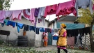 Burul, wife of Kanat Kaliyev's son Adilet, hangs up the laundry to dry at a yard of their family house in Tash Bashat village about 24 kilometers (15 miles) southeast of Bishkek, Kyrgyzstan, Tuesday, Oct. 20, 2020.