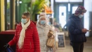 People wear face masks as the walk through a market in Montreal, Wednesday, November 16, 2022. THE CANADIAN PRESS/Graham Hughes