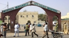 People walk past the entrance gate of the Murtala Mohammed specialist hospital in Kano, Nigeria. At least 25 people in Kano, mostly children, have died in a diphtheria outbreak. (AP Photo/Sunday Alamba)