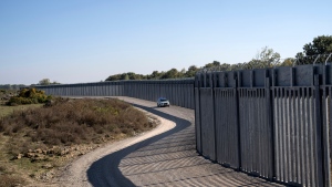 A police border vehicle patrols along a border wall near the town of Feres, along the Evros River which forms the frontier between Greece and Turkey on Sunday, Oct. 30, 2022. (AP Photo/Petros Giannakouris, File)
