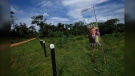 A campaign sign of President Jair Bolsonaro stands next to a farm fence on the access road to the Chico Mendes Extractive Reserve, in Xapuri, Acre state, Brazil, Tuesday, Dec. 6, 2022. Parts of Amazon region, with its legacy of rubber tappers, have turned against his Workers' Party and its vision of a sustainable economy. Many prefer to cut forest and run cattle and have became supporters of Bolsonaro. (AP Photo/Eraldo Peres)