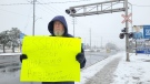 John Alan, pictured on Jan. 22, 2023, is hoping his one-man protest in South Walkerville — where area residents have been complaining about ongoing train whistles going off at odd hours in the night — will put pressure on the railway operator to quiet down. (Sanjay Maru/CTV News Windsor)