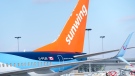 A Sunwing aircraft is parked at Montreal Trudeau airport in Montreal on Wednesday, March 2, 2022. The WestJet Group has announced a deal to buy Sunwing Airlines Inc. THE CANADIAN PRESS/Paul Chiasson