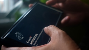 A person holds a smartphone set to the opening screen of the ArriveCan app in a photo illustration made in Toronto on June 29, 2022. THE CANADIAN PRESS/Giordano Ciampini 