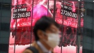 A person walks in front of an electronic stock board showing Japan's Nikkei 225 index at a securities firm, Jan. 24, 2023, in Tokyo. (AP Photo/Eugene Hoshiko)