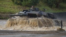 A Leopard 2A6 main battle tank drives through a pool of water during preparations for the 'Land Operations 2017' information training exercise in Munster, Germany, Sept 25, 2017. (Philipp Schulze/dpa via AP, file)