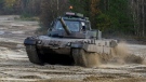 An unidentfied Slovakian soldier drives a Bundeswehr Leopard 2 driving training tank, through the terrain during a training session at the Munster barracks in Munster, near Hanover, Germany, Thursday, Nov. 24, 2022. (Philipp Schulze/dpa via AP)