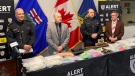 ALERT and Lethbridge Police Service officials stand next to drugs, weapons and cash seized during one of the largest busts in the city's history.