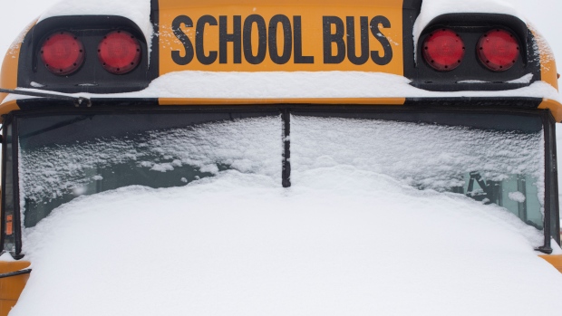 A school bus sits idle after winter conditions suspended the school transportation service in Toronto on Tuesday, February 16, 2021. THE CANADIAN PRESS/Chris Young