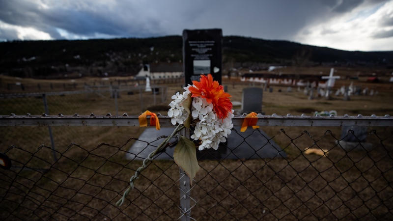 Flowers are seen on a fence surrounding a cemetery on the former grounds of St. Joseph's Mission Residential School, in Williams Lake, B.C., on Wednesday, March 30, 2022. In January, the Williams Lake First Nation announced it had identified 93 "reflections" that could indicate the number of children buried around the site of the former residential school. THE CANADIAN PRESS/Darryl Dyck 