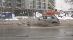 A car drives through water on Vaughan Harvey Boulevard in Moncton, N.B., on Jan. 26, 2023. (Alana Pickrell/CTV)