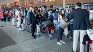 Passengers lineup at the check in counter at Pierre Elliott Trudeau airport, in Montreal, Wednesday, June 29, 2022. THE CANADIAN PRESS/Ryan Remiorz
