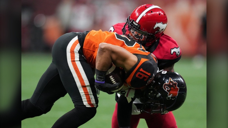 B.C. Lions' Bryan Burnham, front, is tackled by Calgary Stampeders' Brad Muhammad during the first half of CFL football game in Vancouver, on Saturday, Sept. 24, 2022. Muhammad re-signed with the Calgary Stampeders on Thursday. (THE CANADIAN PRESS/Darryl Dyck)