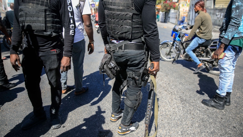 Armed police officers stands with his weapons drawn during a protest to denounce bad police governance, in Port-au-Prince, Haiti, Thursday, Jan. 26, 2023. (AP Photo/Odelyn Joseph)