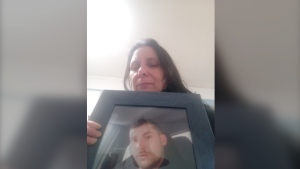 Stacey Cook sits with a framed image of her son, Colton Cook. (Courtesy: Stacey Cook)