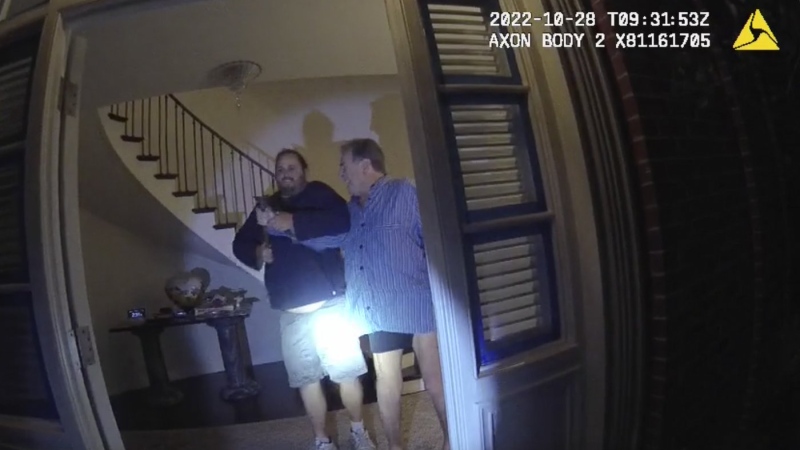 In this image taken from San Francisco Police Department body-camera video, the husband of former U.S. House Speaker Nancy Pelosi, Paul Pelosi, right, fights for control of a hammer with his assailant during a brutal attack in the couple's San Francisco home on Oct. 28, 2022. (San Francisco Police Department via AP)