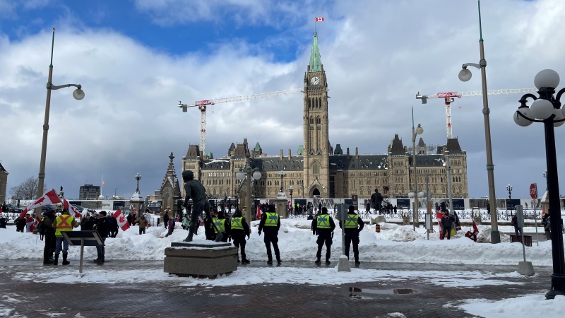 Ottawa police and Ontario Provincial Police officers monitor a rally on Wellington Street on Saturday. A rally was planned for Parliament Hill to mark the one-year anniversary of the start of the 'Freedom Convoy'. (Josh Pringle/CTV News Ottawa)