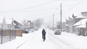 A cyclist rides along a road in Hamilton, Ont., during a winter storm, Wednesday, January 25, 2023. (THE CANADIAN PRESS/Nick Iwanyshyn)