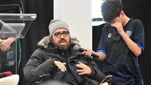 Ayman Derbali, injured victim of the 2017 mosque shooting, speaks of the ordeal as his son Ayoub cries while holding the microphone during a ceremony, Sunday, January 29, 2023 at the mosque in Quebec City. An emotional ceremony took place today marking the sixth anniversary of the Quebec City mosque shooting, held for the first time in the same room where many of the victims were killed. THE CANADIAN PRESS/Jacques Boissinot