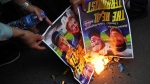 Muslim protesters burn posters during a rally outside the Swedish Embassy in Jakarta, Indonesia, Monday, Jan. 30, 2023.  (AP Photo/Tatan Syuflana) 