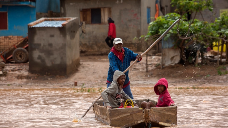 A man steers his boat that is used by residents to move around the street flooded with rain water in Antananarivo, Madagascar, Jan. 28, 2023.  (AP Photo/Alexander Joe)