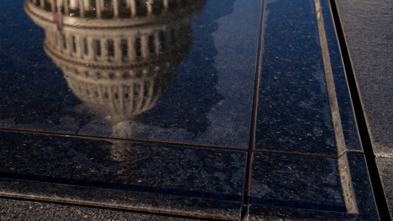 The dome of the U.S. Capitol Building is visible in a reflection on Capitol Hill in Washington, Jan. 23, 2023. (AP Photo/Andrew Harnik)