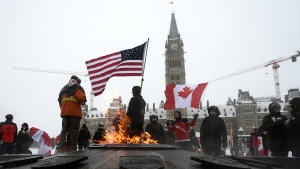 Demonstrators hold flags as they mark the one year anniversary of the Freedom Convoy on Parliament Hill in Ottawa, on Sunday, Jan. 29, 2023. (Justin Tang/THE CANADIAN PRESS)