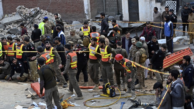 Security officials and rescue workers gather at the site of suicide bombing, in Peshawar, Pakistan, Monday, Jan. 30, 2023. A suicide bomber struck Monday inside a mosque in the northwestern Pakistani city of Peshawar, killing multiple people and wounding scores of worshippers, officials said. (AP Photo/Zubair Khan)