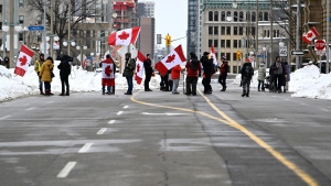 Demonstrators stand on Wellington Street as they mark the one year anniversary of the Freedom Convoy in Ottawa, on Saturday, Jan. 28, 2023. (Justin Tang/THE CANADIAN PRESS)