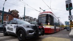Police cars surround a TTC streetcar on Spadina Ave., in Toronto on Tuesday, January 24, 2023.  THE CANADIAN PRESS/Arlyn McAdorey 