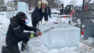 Larry MacFarlane (right) works away at an ice sculpture on display near the National War Memorial. (Jackie Perez/CTV News Ottawa)