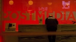 A security guard stands by the front reception desk at Postmedia's Toronto headquarters on Monday, March 12, 2018. Unifor says Postmedia has cut more than 75 jobs at the Windsor Star by outsourcing printing. The union says printing is being transferred to a Toronto printer, and the papers will then be shipped back to Windsor for distribution. (THE CANADIAN PRESS/Chris Young)
