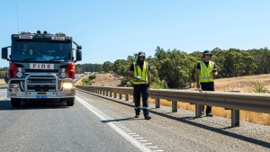 In this photo provided by the Department of Fire and Emergency Services, its members search for a radioactive capsule believed to have fallen off a truck being transported on a freight route on the outskirts of Perth, Australia, Jan. 28, 2023. (Department of Fire and Emergency Services via AP)