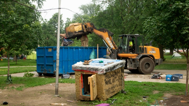 A city truck disposes of a resident's belonging as municipal officials and police work to clear Alexandra Park encampment in Toronto on Tuesday July 20, 2021. THE CANADIAN PRESS/Chris Young
