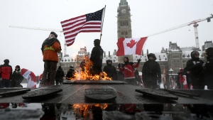 Demonstrators hold flags as they mark the one year anniversary of the Freedom Convoy on Parliament Hill in Ottawa, on Sunday, Jan. 29, 2023. (THE CANADIAN PRESS/Justin Tang)