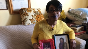Janice Walker holds up photographs of her recently deceased mother while awaiting news about her eviction. (Beth Macdonell)