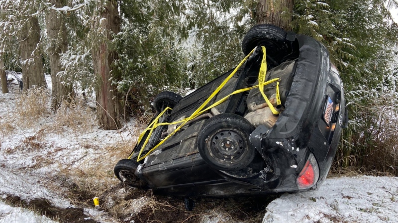 A flipped car is seen in Langley, B.C. on Jan. 31, 2023. 