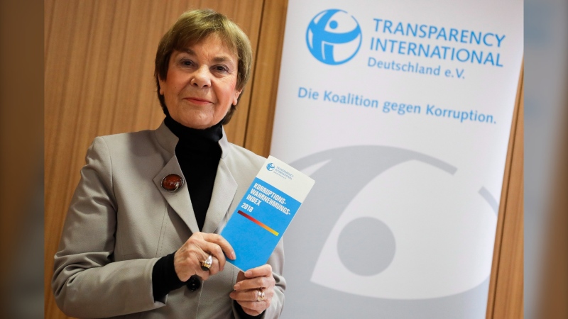 Edda Mueller, chairwoman of Transparency International Germany e.V. poses for the media with the Corruption Perceptions Index 2018, prior to the presentation of the yearly report at a news conference in Berlin, Germany, Tuesday, Jan. 29, 2019. The flyer reading: 'Corruption Perceptions Index 2018'. (AP Photo/Markus Schreiber)