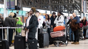 Travellers line up at the Ottawa International Airport, as airlines cancel or delay flights during a major storm in Ottawa, on Friday, Dec. 23, 2022. THE CANADIAN PRESS/Justin Tang