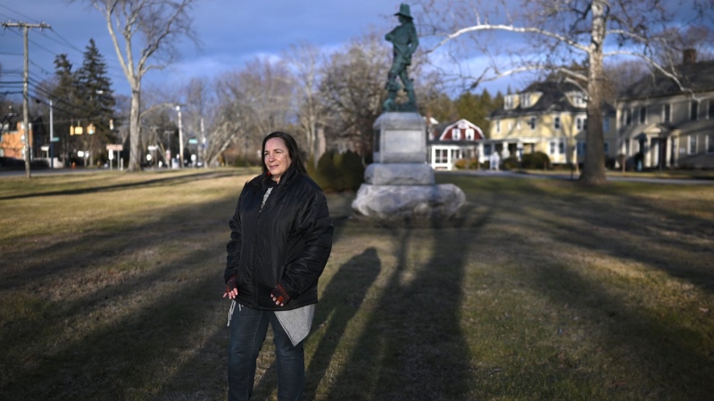 In this Tuesday, Jan. 24, 2023 photo, Beth Caruso, author and co-founder of the CT Witch Trial Exoneration Project, which was created to clear the names of the accused, stands on the old town green in Windsor, Conn., where in 1651, an accident during a local militiamen training exercise led to the accusation of witchcraft and hanging of Lydia Gilbert. (AP Photo/Jessica Hill)