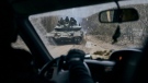 A Ukrainian tank with soldiers is seen through a car window close to the frontline near Kremenna in the Luhansk region, Ukraine, on Jan. 15, 2023. (LIBKOS AP)