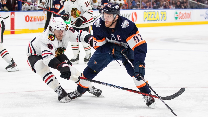 Chicago Blackhawks' Jake McCabe (6) tries to stop Edmonton Oilers' Connor McDavid (97) during second period NHL action in Edmonton on Saturday January 28, 2023. McDavid heads into the NHL all-star break with a league-leading 92 points in 50 games - 16 more than teammate Leon Draisaitl, a distant second in the overall scoring race. THE CANADIAN PRESS/Jason Franson